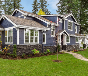 Modern two-storey home with blue siding, white trim, and stone accents, featuring professionally specified exterior paint colours