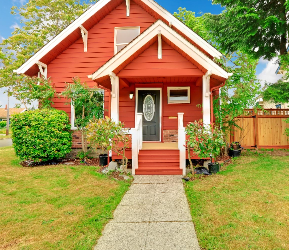 Red heritage-style house with white trim and front porch, showcasing classic exterior paint colour combinations
